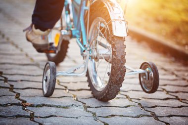 Güneşli bir gün de asfalt yol bisiklet çocuk. Arkadan Görünüm.