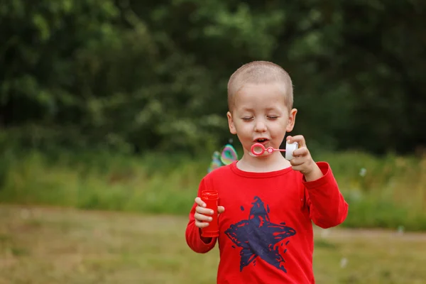 Anak meniup gelembung sabun. Kid meniup gelembung di alam — Stok Foto