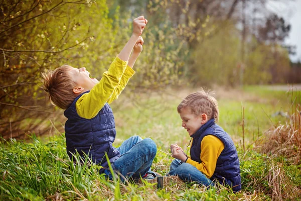 Retrato de dos amigos jugando piedra, tijeras, juego de papel en el fondo de la naturaleza. Concepto de diversión y ocio —  Fotos de Stock