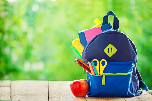 Mochila Full School con manzana sobre fondo de madera y naturaleza . —  Fotos de Stock