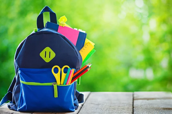 Full School backpack on wooden and nature background — Stock Photo, Image