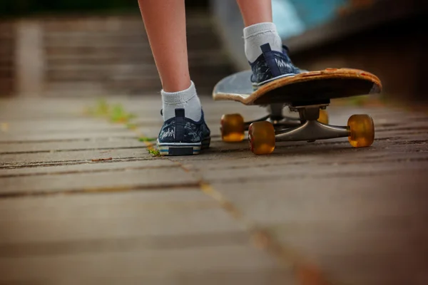 Benen op skateboard close-up op de straat in zonnige dag — Stockfoto