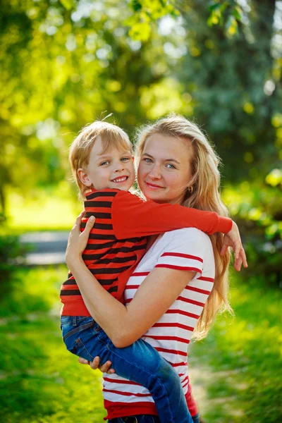 Uma mãe e um filho às suas mãos na natureza. Crianças e happ — Fotografia de Stock