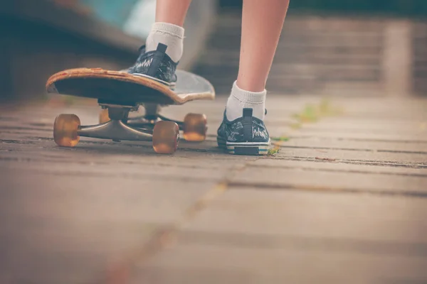 Benen op skateboard close-up op de straat in zonnige dag. Toning ik — Stockfoto