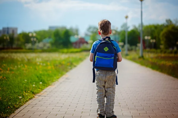 Jongetje met een rugzak naar school gaan. Achteraanzicht. — Stockfoto