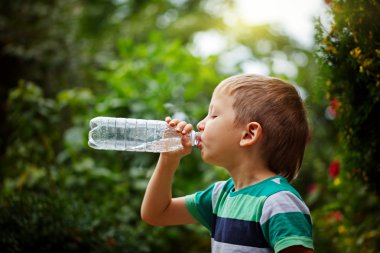 Küçük çocuk plastik şişe maden suyu içme dışarı