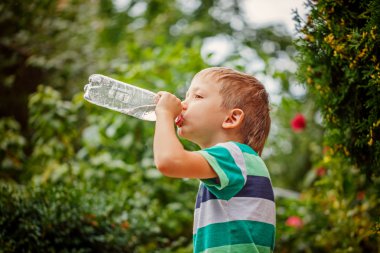 Küçük çocuk plastik şişe maden suyu içme dışarı