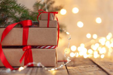 Yılbaşı hediyeleri noel ağacının altında sönmüş ışıklarla duruyor. El yapımı hediye kutuları. Noel tatili konforu, ruh hali konsepti.