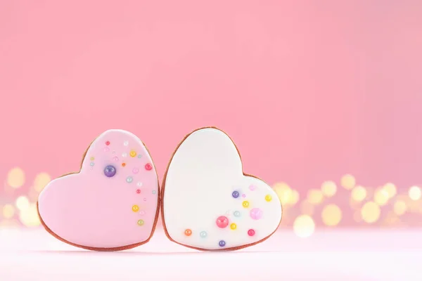 Två hjärtan formade pepparkakor för alla hjärtans dag, mors dag eller födelsedag på rosa bakgrund. — Stockfoto