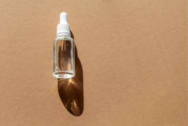 Serum için kozmetik damlası şişesi, mikiler toneri ve kahverengi arka planda emülsiyon. Cilt bakımı, hidrasyon ve beslenme oksijen kabarcıkları. Güzellik ürünü..