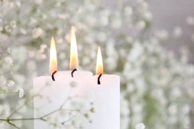 Yanan mumlar ve beyaz çiçekli çıngıraklı yılan. Masada mesaj için yer var. Güzel dekorasyon fikirleri.