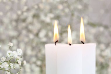 Yanan mumlar ve beyaz çiçekli çıngıraklı yılan. Masada mesaj için yer var. Güzel dekorasyon fikirleri.