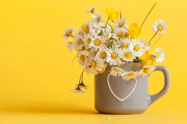 黄色の背景に灰色のカップにデイジーの花の花束 春はまだ小さなカモミールとの生活 グリーティングカード — ストック写真