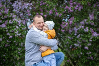 Küçük oğlunun sevgi dolu babasını kucaklaması ve öpmesi. Mutlu aile ve babalar günü..
