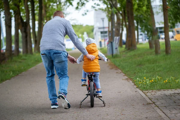 Tata Pomaga Synowi Jeździć Rowerze Letnim Parku Dzieciak Jeżdżący Rowerze — Zdjęcie stockowe