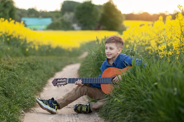 Retrato Chico Lindo Tocando Una Guitarra Sentado Carretera Campo Amarillo —  Fotos de Stock