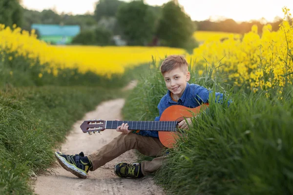 Retrato Chico Lindo Tocando Una Guitarra Sentado Carretera Campo Amarillo —  Fotos de Stock