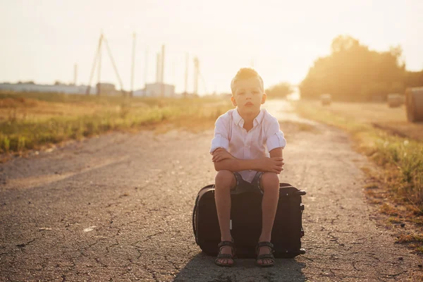 Dziecko siedzi na walizkę w słoneczny dzień lata, Podróże — Zdjęcie stockowe