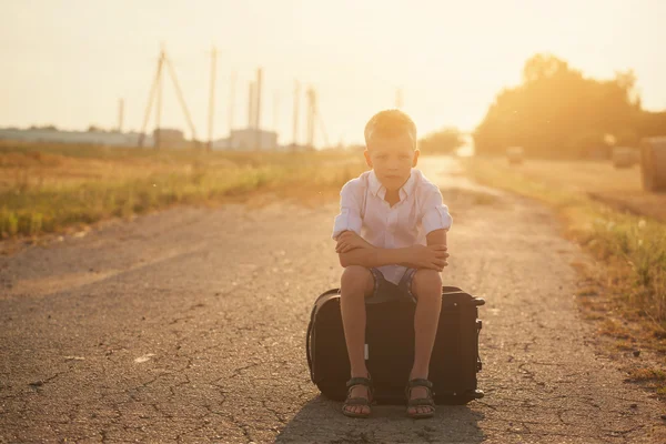 夏の晴れた日、旅行でスーツケースに座っている子供 — ストック写真