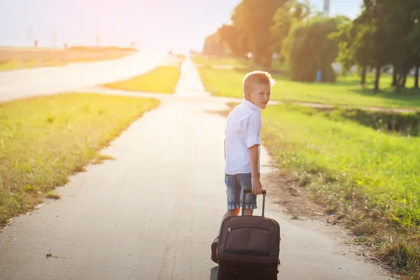 Little boy traveler with a suitcase on the summer road — Stock Photo, Image