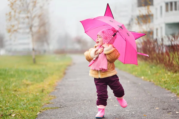 The little girl under an umbrella in the fall in autumn day — Stock Photo, Image
