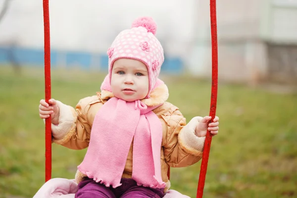 Adorable girl having fun on a swing on autumn day — Stock Photo, Image