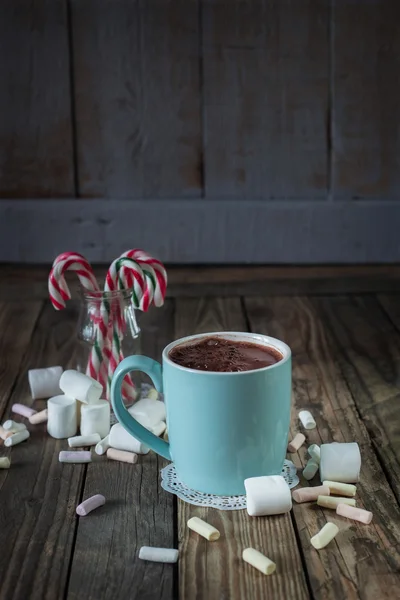 Taza llena de chocolate caliente cerca de malvavisco y bastones de caramelo i — Foto de Stock