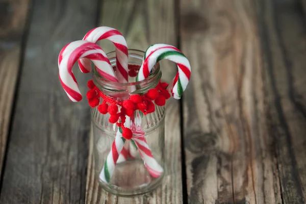 Weihnachtssüße Bonbons im Glas auf dem Holzhintergrund — Stockfoto