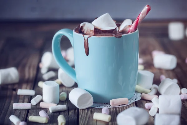 Mug filled with hot chocolate and marshmallow  and candy, toned — Stock Photo, Image