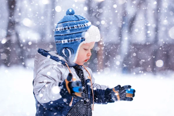 The little boy catches snowflakes in the frosty winter afternoon — Stock Photo, Image