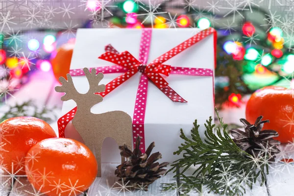Vánoční dárky s červenou stužku a mandarinky a kužely, prosinec — Stock fotografie