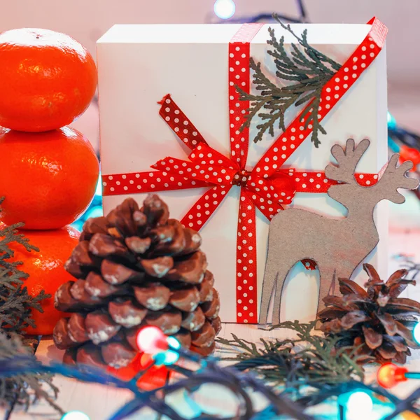 Weihnachtsgeschenke mit roter Schleife und Mandarinen und Tannenbaum — Stockfoto