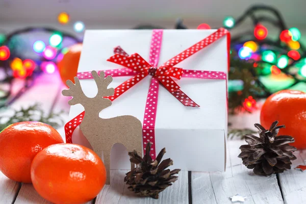 Vánoční dárky s červenou stužku a mandarinky a jedle s — Stock fotografie