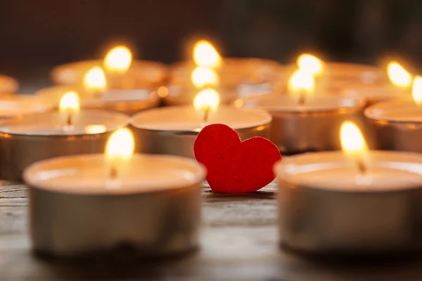 Красное сердце со свечами на фоне света, концепция любви — стоковое фото
