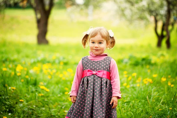 Belle fille heureuse jouant dans un champ de fleurs jaunes sur — Photo