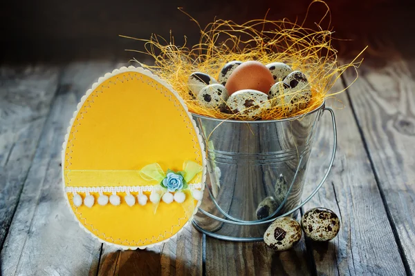 Желтая пасхальная карточка и перепелиные яйца в ведре, Пасхальное украшение — стоковое фото
