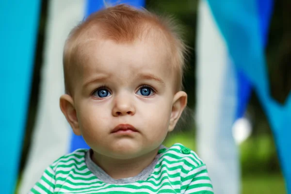 Serious little boy portrait with big opened  eyes on a blue and — Stock Photo, Image