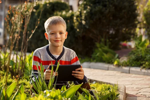 Mutlu çocuk açık havada onun tablet bilgisayar kullanarak oynamak için — Stok fotoğraf