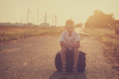 Çocuk bavula güneşli gün yaz, seyahat oturuyor.