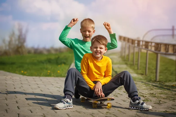 Twee kleine jongen schaatsen op de straat in de zomer — Stockfoto