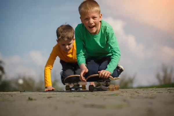 Dva chlapce, bruslení na ulici v létě — Stock fotografie