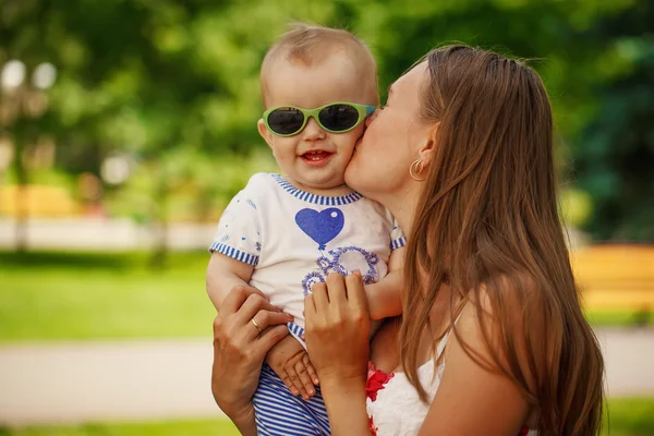 Abraçando a mãe feliz e o filho pequeno no fundo verde em Summe — Fotografia de Stock