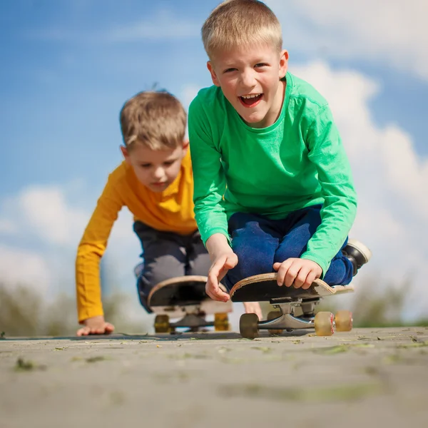 Twee kleine jongen schaatsen op de straat in zomerdag — Stockfoto