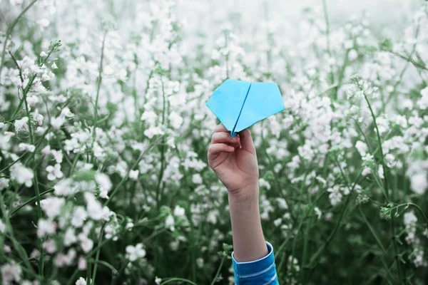 Avion en papier dans les mains des enfants sur fond blanc . — Photo