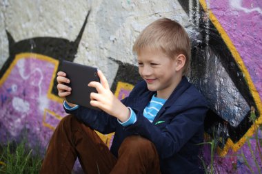 Küçük çocuk yetiştirmek ve oynamak için onun tablet içine emilir.