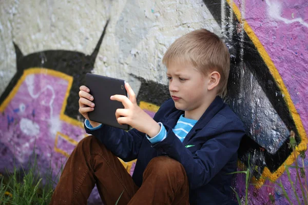 Kleiner Junge zum Lernen und Spielen in sein Tablet vertieft. — Stockfoto