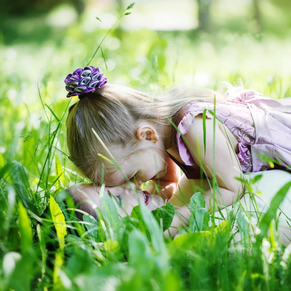 Happy family. Mother and  daughter lie on a grass, embrace  in t — Stock fotografie