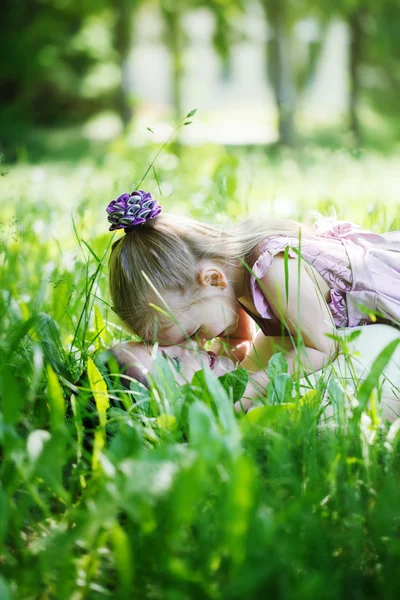 Happy family. Mother and the daughter lie on a grass, embrace in — Stok fotoğraf