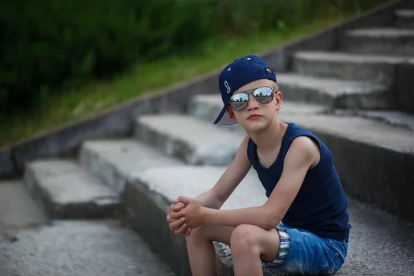 Portrait de petit garçon à la mode en lunettes de soleil et casquette. Enfant — Photo