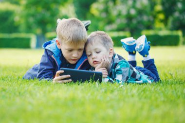 Tablet, yingon çim suny gün parkta kullanma kardeşler